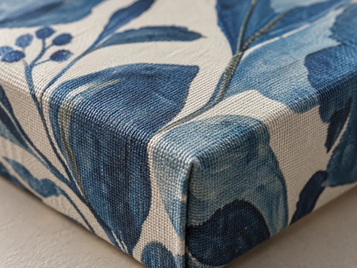 The corner of a canvas printed with blue leaves.