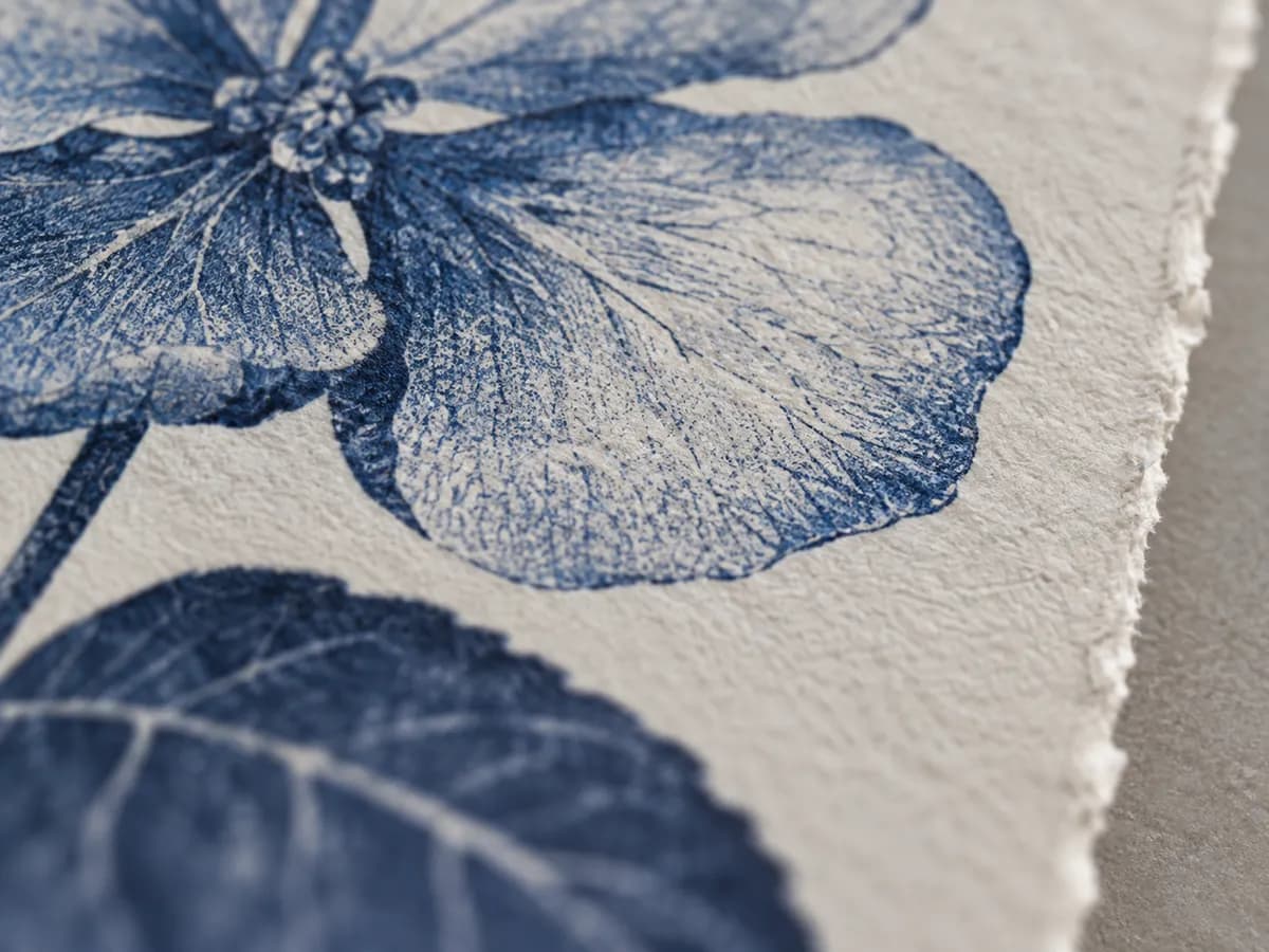 A close look at a blue botanical print on textured paper.